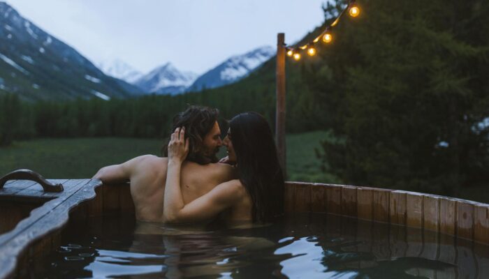 Couple enjoying a romantic outdoor hot tub break with mountain views
