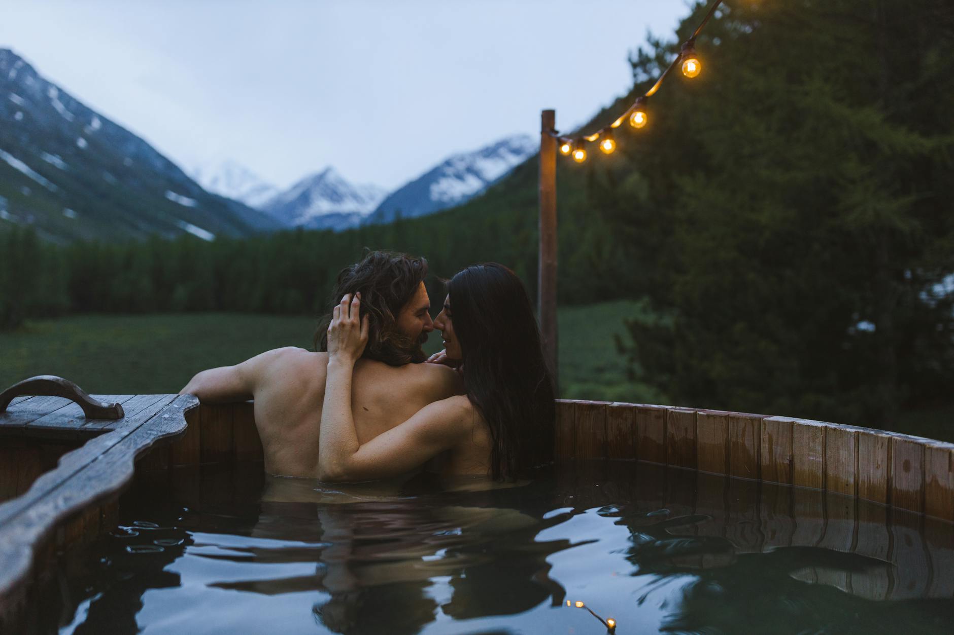 Couple enjoying a romantic outdoor hot tub break with mountain views