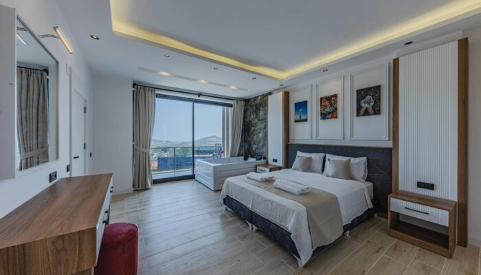 Modern lodge bedroom with private hot tub and scenic balcony view