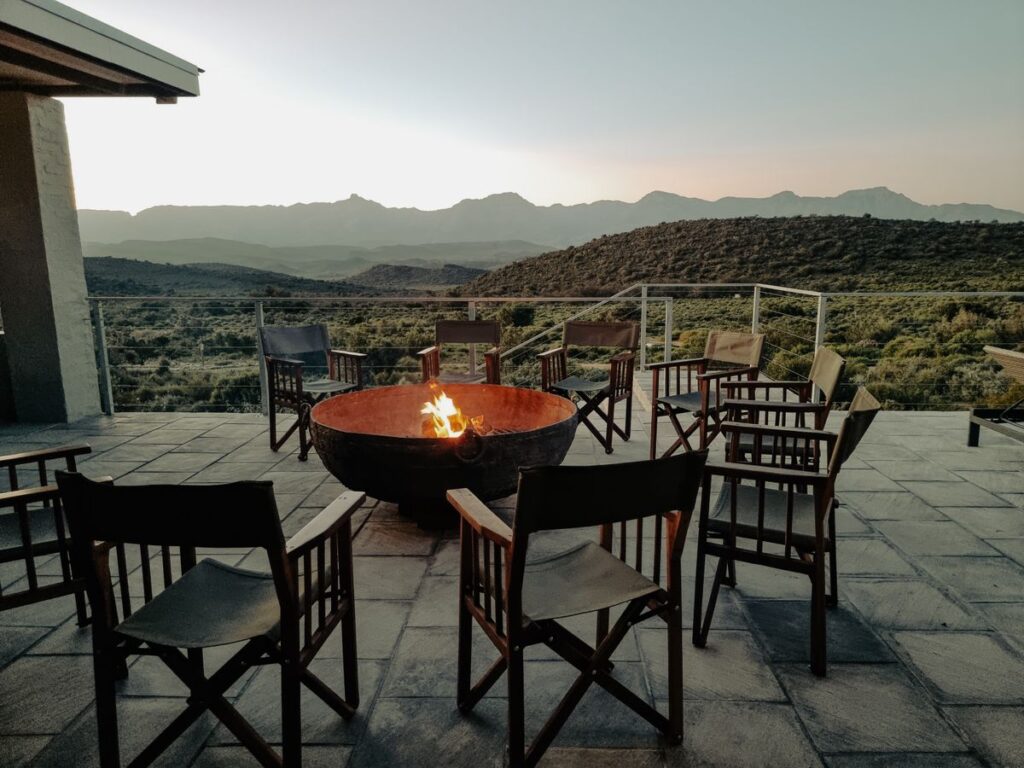 Outdoor firepit surrounded by chairs on a terrace, illustrative image