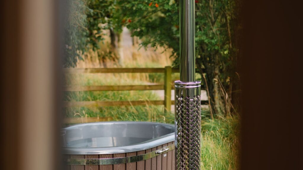 Wood-fired outdoor hot tub in a Scottish garden, illustrative image